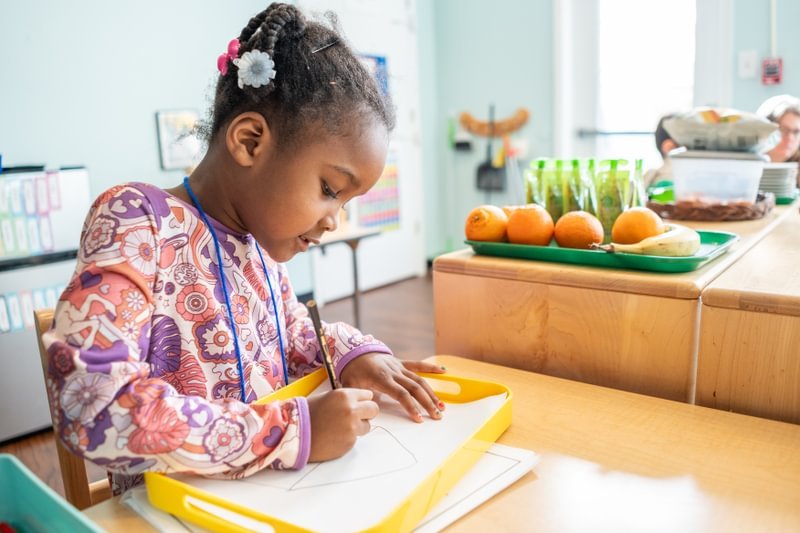 Student writing in classroom.