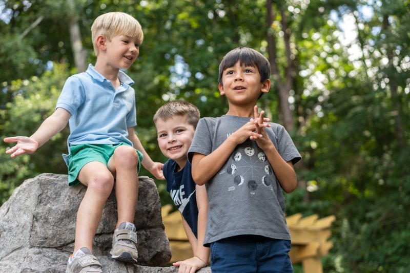 Three students smiling on a playground.