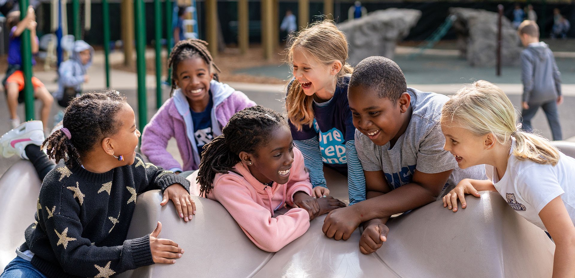 Diverse group of students smiling on a playground