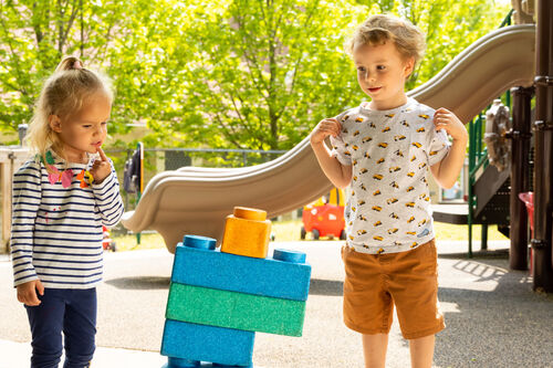 Children play on the playground balancing blocks