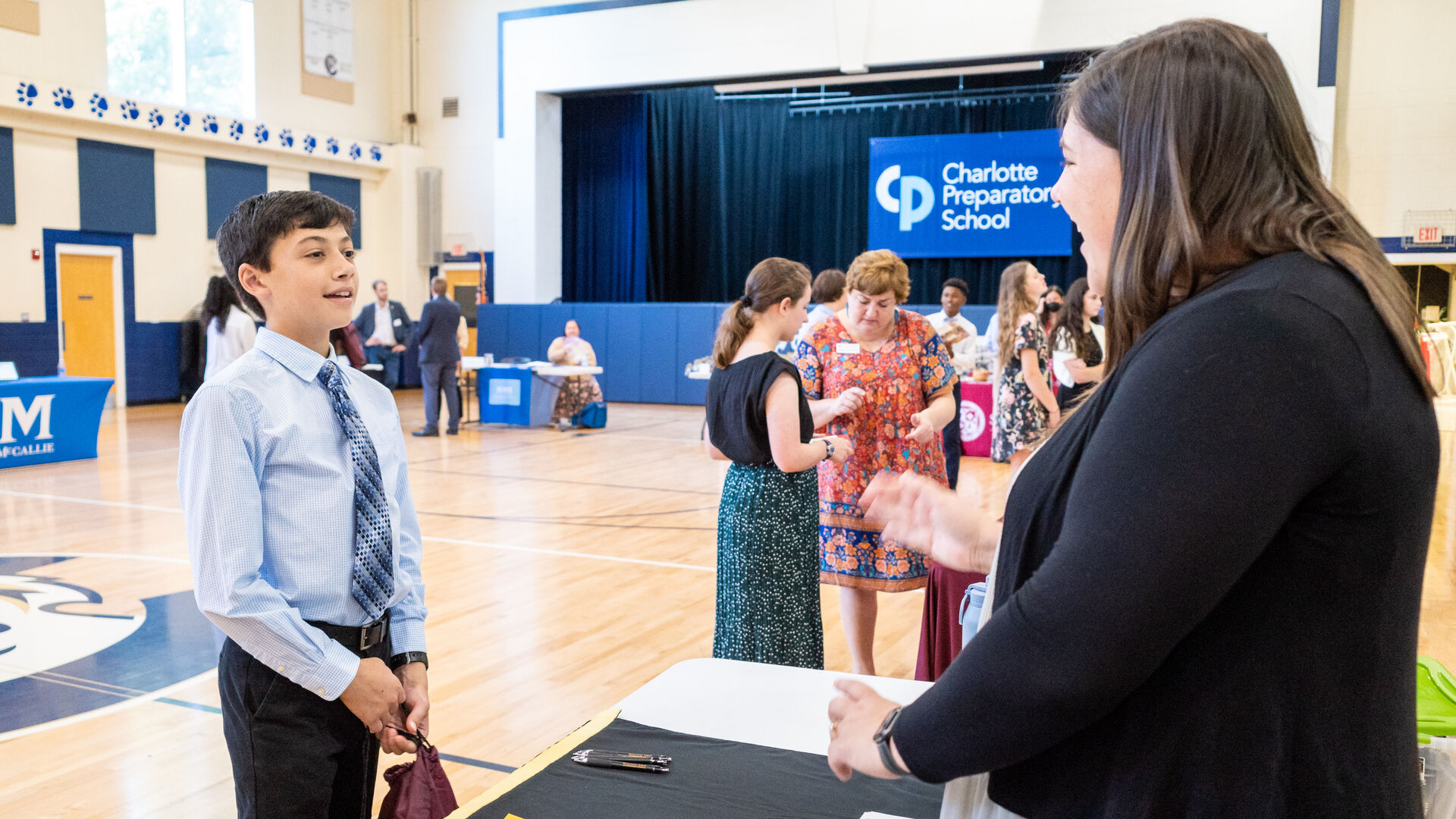 A student smiles brightly at an admissions representative