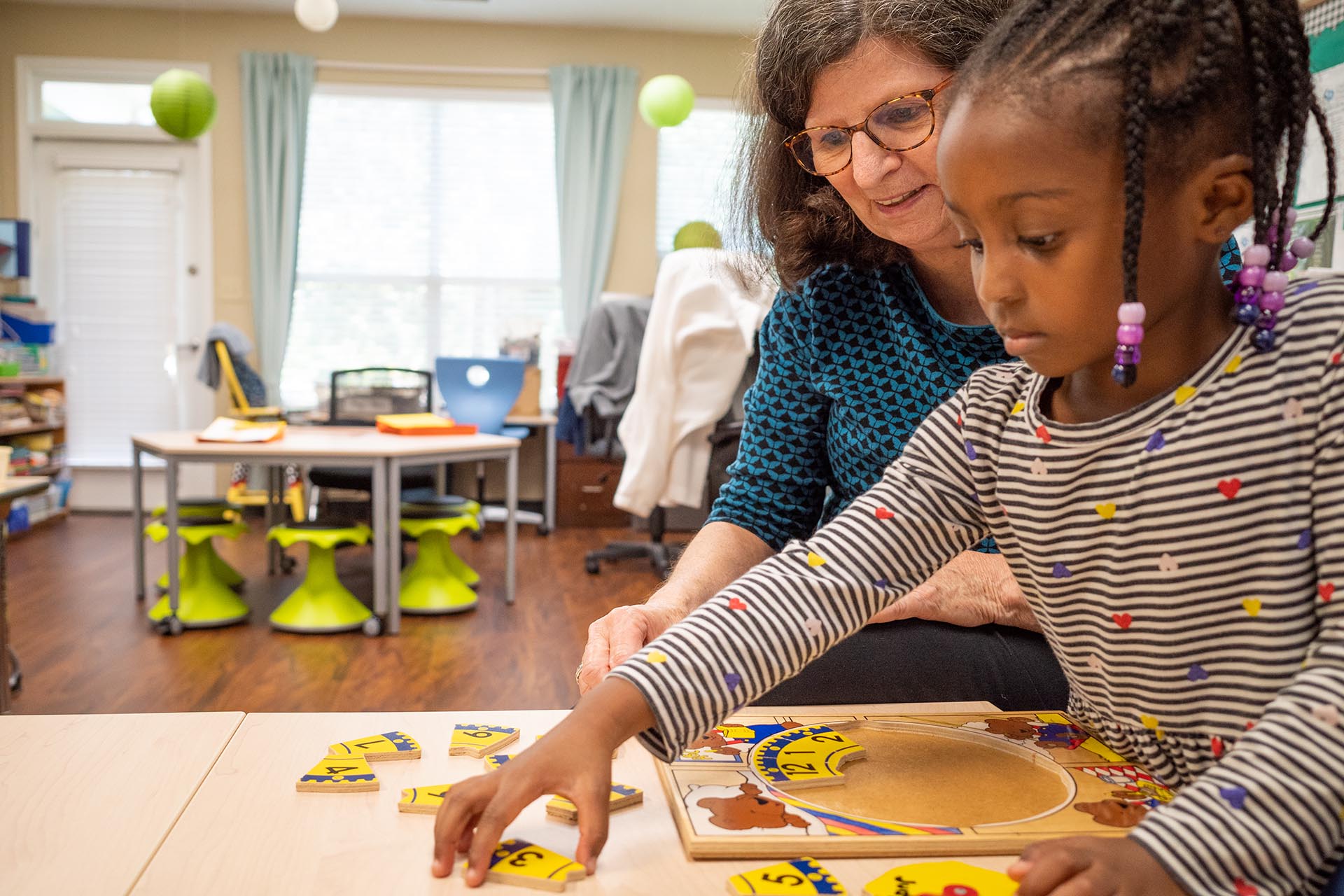 Ms. Pater helps a student with a puzzle