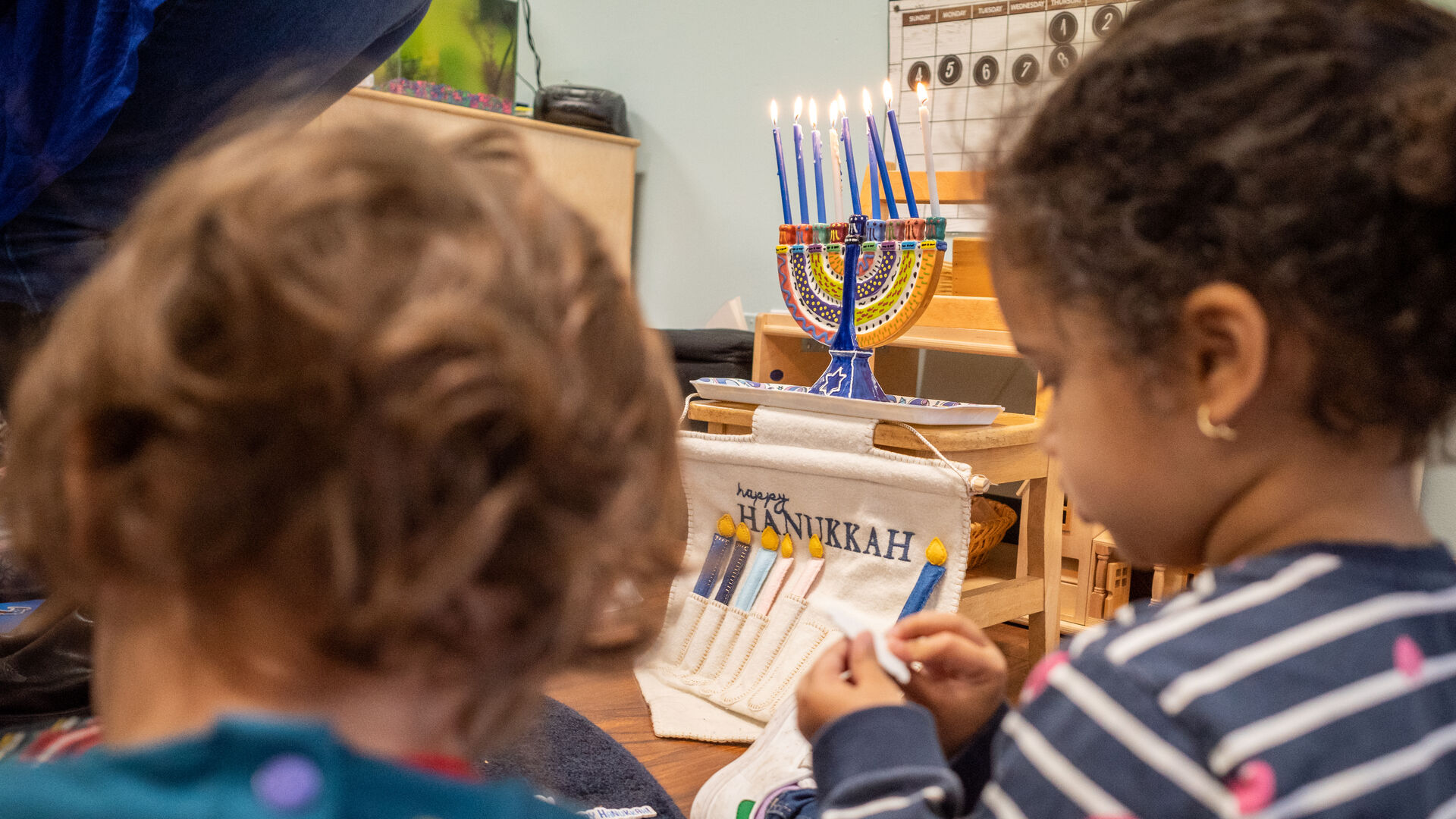 Students sit near a Hannukah display