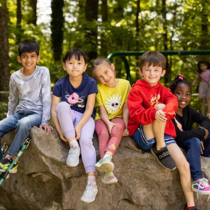 students sitting together on a big rock