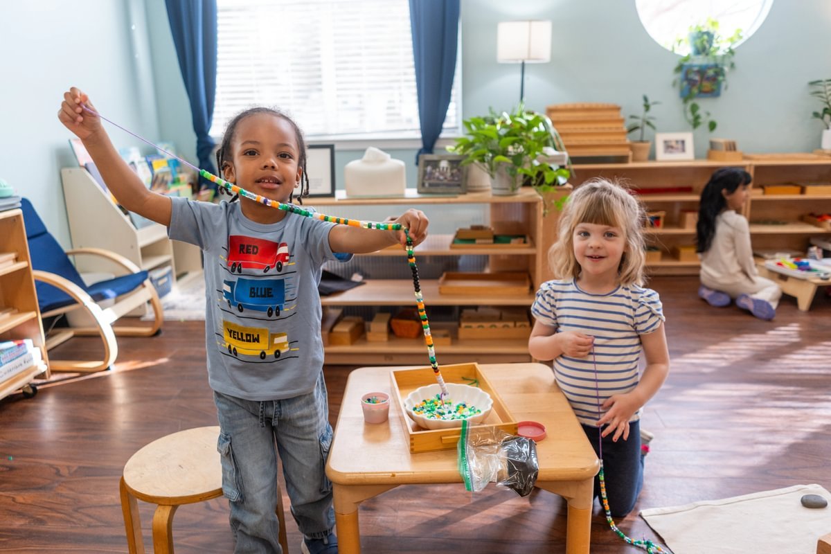 Early school students doing an activity with beads