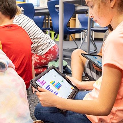 a student uses an ipad for programming